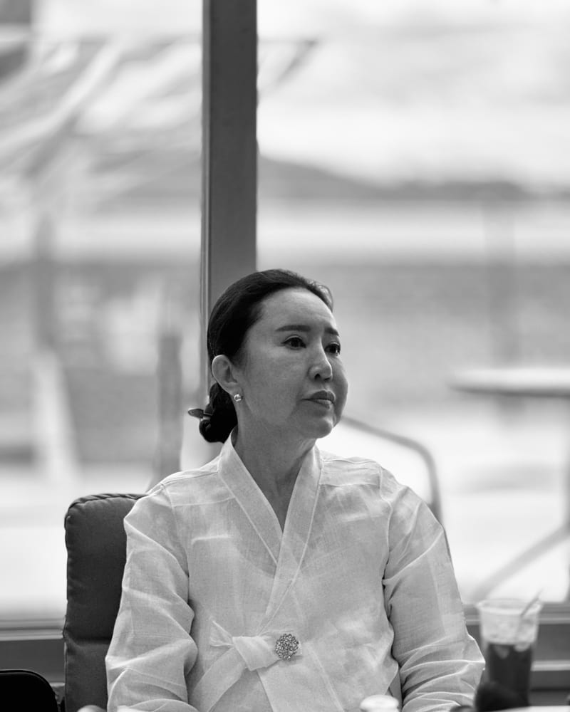 하늘신궁 대표 — 흰 한복을 입고 창가에 앉은 흑백 인물 사진