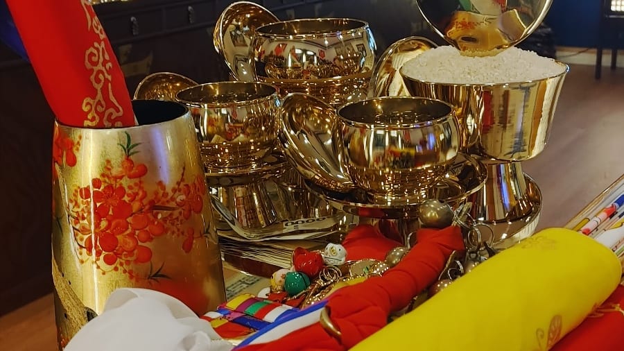 신당 제단 앞에 놓인 놋그릇과 쌀, 오방색 천